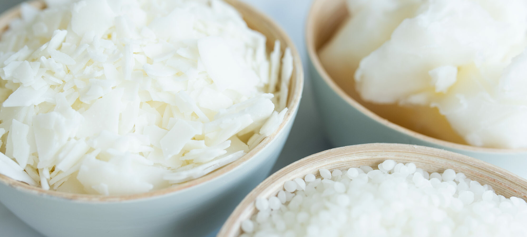 Bowls of candle wax in flaked and pastilled form